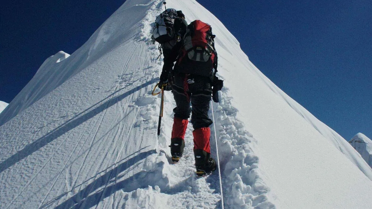 Climber on the snow ridge of Island Peak with fixed rope on an Everest climbing tour in the Khumbu, Nepal