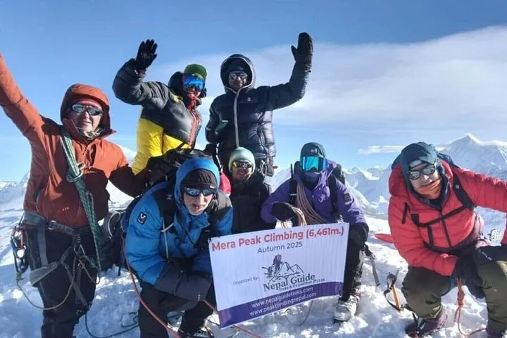 Team holding a Mera Peak climbing banner on the summit snow on an Everest climbing tour, Hinku valley, Nepal